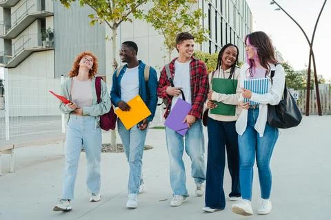 Group of cheerful students sharing laughter while walking together with colorful Stock Photos