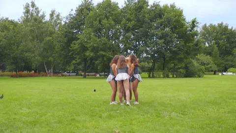 Group of cheerleaders training acrobatic elements lifting girl in air outdoors Stock Footage 137331140