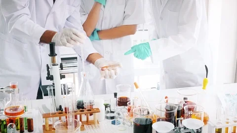 Group of chemist working in a lab, examine chemical experiment. Stock Footage 99016314