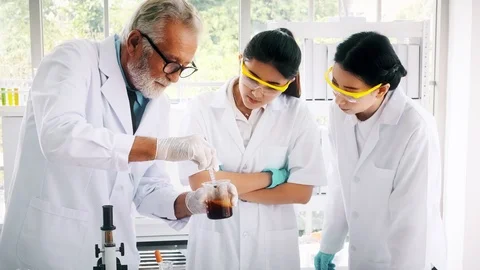 Group of chemist working in a lab, examine mixed chemical. Stock Footage 99016330