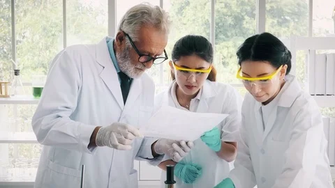 Group of chemist working in a lab, reading notes. Stock Footage 99016335