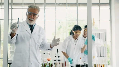 Group of chemist working in a lab, taking notes and writing on glass display. Stock Footage 99013722
