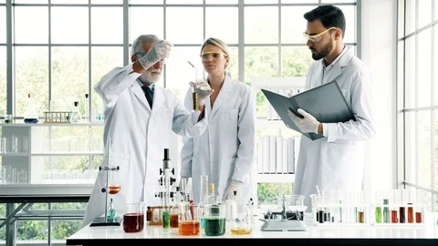 Group of chemist working in a lab, taking notes. Stock Footage 99014624