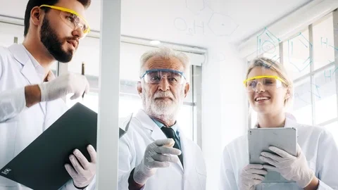Group of chemist working in a lab, taking notes and writing on glass display. Stock Footage 99016668
