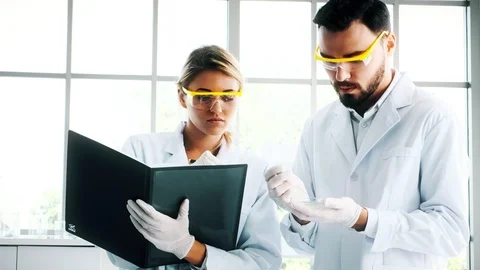 Group of chemist working in a lab, taking notes. Stock Footage 99016683
