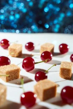 Group of cherry on a white background with cubes of reed sugar and shadows. C Stock Photos