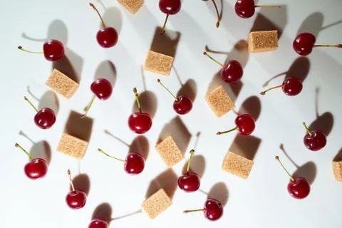 Group of cherry on a white background with cubes of reed sugar and shadows Stock Photos