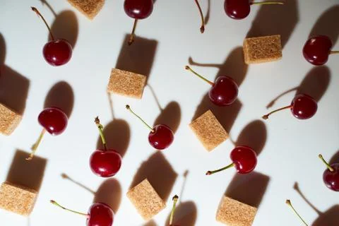 Group of cherry on a white background with cubes of reed sugar and shadows Stock Photos