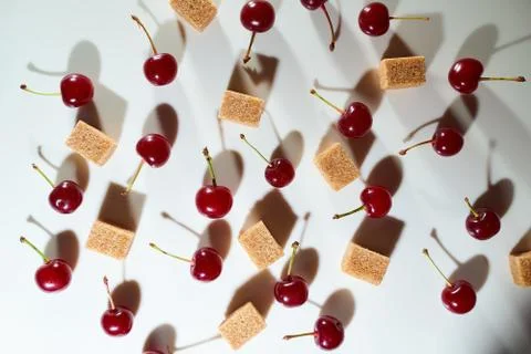 Group of cherry on a white background with cubes of reed sugar and shadows Stock Photos