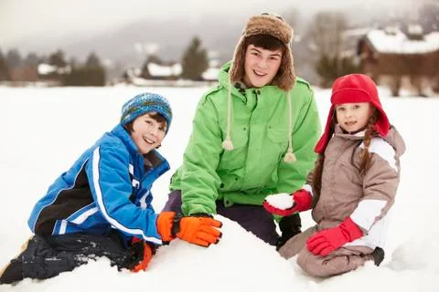 Group Of Children Building Snowman Wearing Woolly Hats Stock Photos