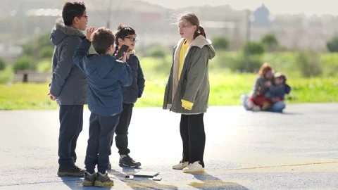 Group of children interacting and playing in a schoolyard Stock Footage 327856439