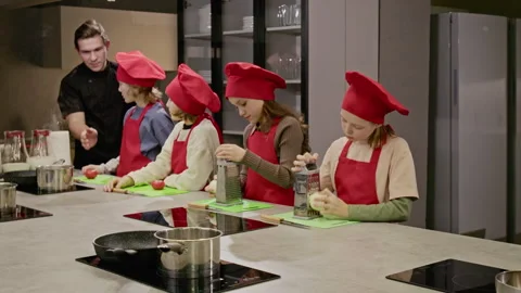 Group of Children Learning to Cook and Grating Cheese with Chef Stock Footage 339497620