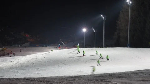 Group of children is learning to ski with the ski instructor in the evening Stock Footage 124661025