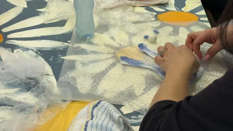 A group of children make a toy from wool, wet felting a blank and squeeze water  Video stock 306536143
