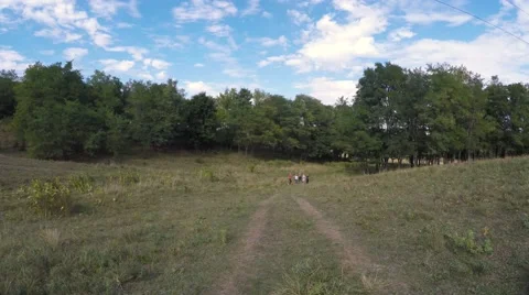 A group of children makes a run through the park with a teacher. Video stock 54635572