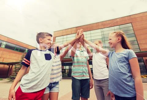 Group of children making high five at school yard Stock Photos
