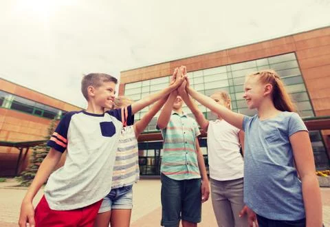 Group of children making high five at school yard Stock Photos