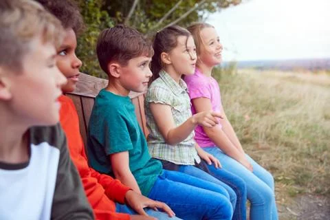 Group Of Children At Outdoor Activity Camp Resting On Bench During Walk Through Stock Photos