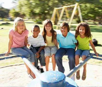 Group Of Children Riding On Roundabout In Playground Stock Photos