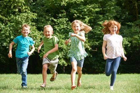 Group Of Children Running Towrads Camera In Playground Stock Photos