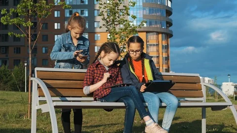 A group of children sitting on a bench. Видео 113783731