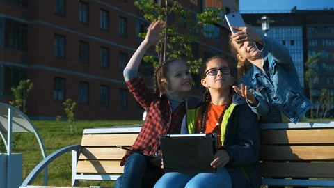 A group of children sitting on a bench. Видео 113783898