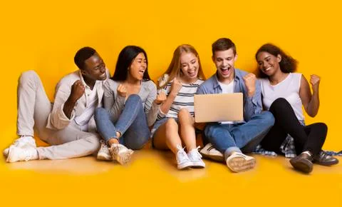 Group of classmates checking exam results online, using laptop 스톡 사진