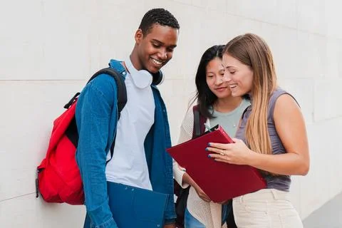 Group of classmates talking about the class, standing at university campus Stock Photos