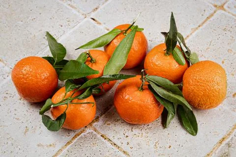 Group of clementines with leaves in close-up on a table Foto stock