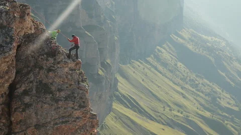 A group of climbers discussing a plan of action standing on the edge of the Stock Footage 97768142