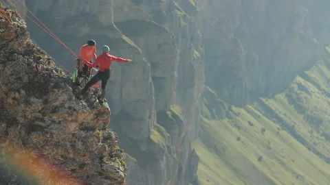 A group of climbers discussing a plan of action standing on the edge of the Stock Footage 97768353