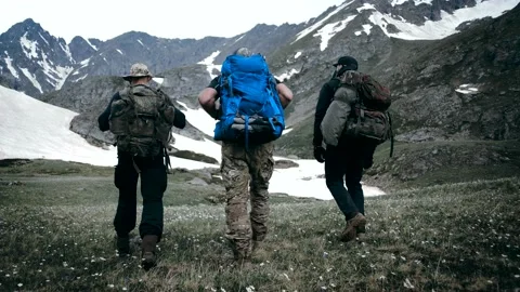 A group of climbers move along the valley towards the summit Stock Footage 138691501
