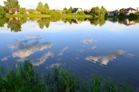 A group of clouds in the sky is reflected in the water of the lake Stock Photos