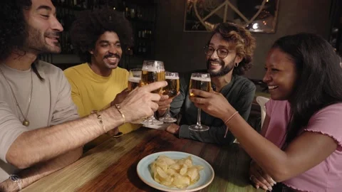 Group of colleague workers toast with beer in the restaurant bar after work at Stock Footage 224337357