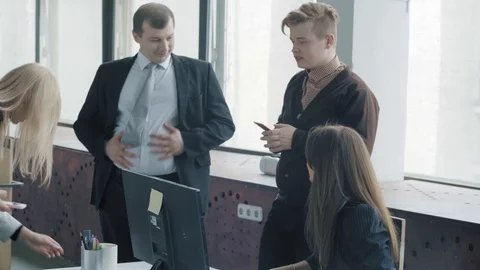 A group of colleagues communicates cheerfully with each other. Employees are Stock Footage 124329620