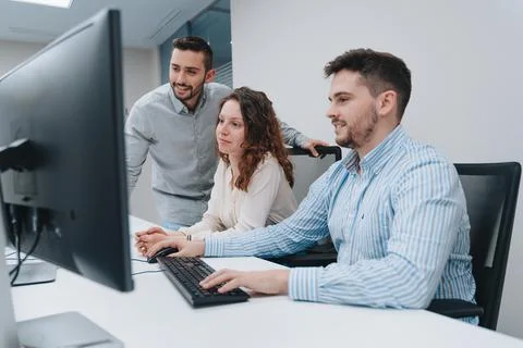Group of colleagues trying to solve a problem on a computer Stock Photos