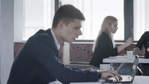 A group of colleagues working in the office with laptops. The camera slides Stock Footage 124705383