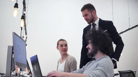 Group of college co-workers looking at laptop computer discussing project Stock-Footage 231556824
