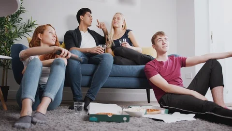 Group Of College Students In Shared House Watching TV And Eating Pizza Stock Footage 119831590