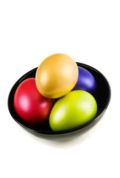 Group of colored Easter Eggs in saucer on white background. Stock Photos