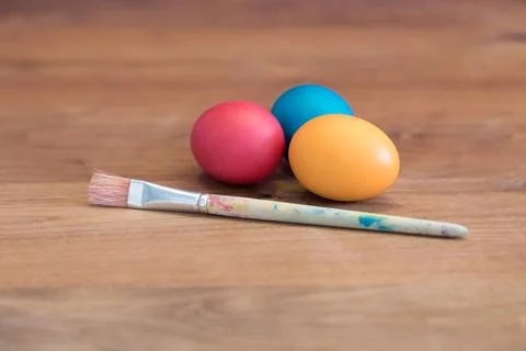 Group of colored easter eggs together with single paint brush. Handmade paste Stock Photos