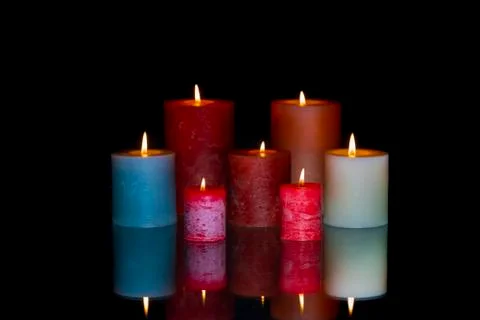 Group of colored lit candles with reflection Foto stock
