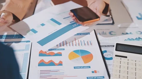 Group of confident business people point to graphs and charts to analyze ma.. Stock Footage 344632453