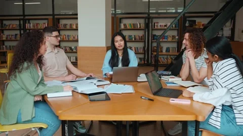 Group of confident multicultural students studying and talking in library Stock Footage 250339534