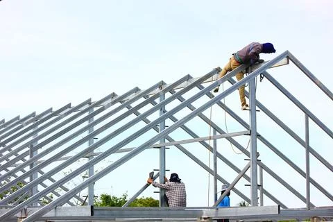 Group of construction  worker welding new house roof beams Foto stock