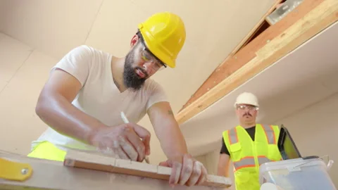 A group of construction workers diligently measuring wood inside a busy workshop Video stock 305782254