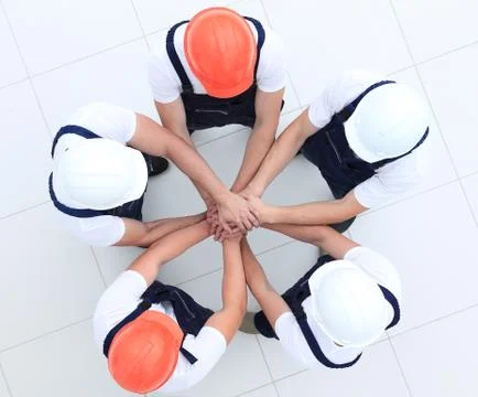 Group of construction workers with hands clasped together Stock Photos