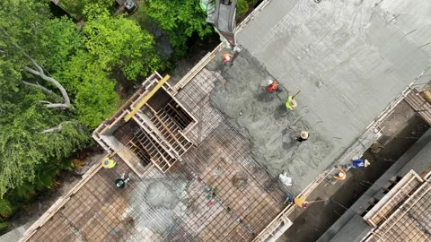 Group of construction workers in hardhats and reflective vests pouring wet Stock Footage 245959861