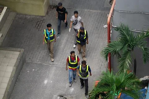Group of Construction Workers in High Visibility Vests Walking on City Sidewa Stock Photos