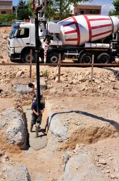 Group of construction workers spreading freshly poured concrete mix Stock Photos